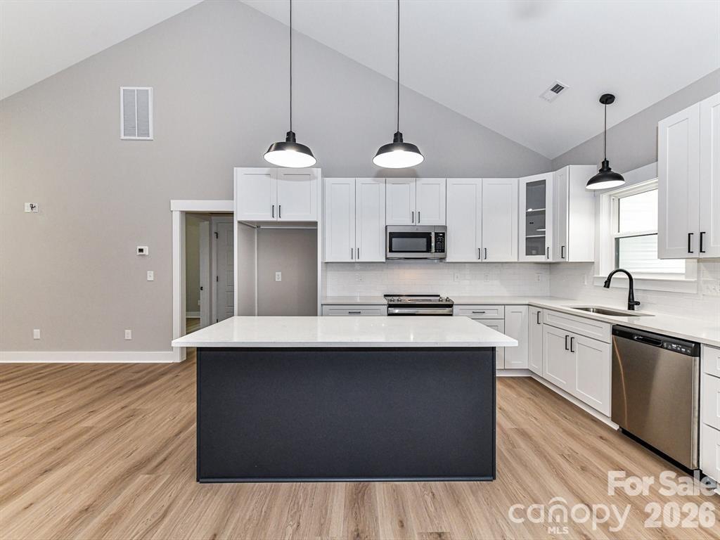 6720 Jesse Rushing Road Marshville, NC 28103 - Photo 12 of 28 a kitchen with stainless steel appliances granite countertop a sink a stove and a wooden floors
