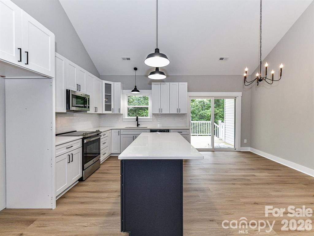 6720 Jesse Rushing Road Marshville, NC 28103 - Photo 13 of 28 a large kitchen with stainless steel appliances granite countertop a stove a sink dishwasher a refrigerator and a fireplace with wooden floor