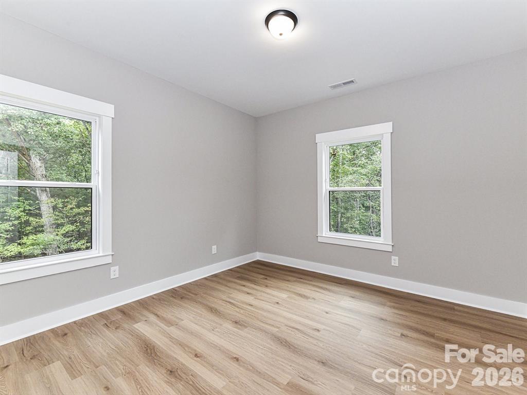 6720 Jesse Rushing Road Marshville, NC 28103 - Photo 19 of 28 an empty room with wooden floor and windows