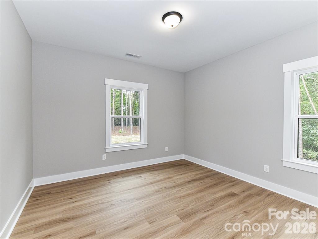 6720 Jesse Rushing Road Marshville, NC 28103 - Photo 21 of 28 a view of an empty room with wooden floor and a window