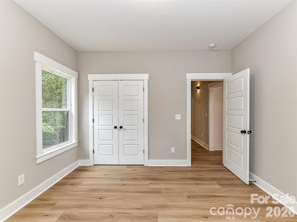 6720 Jesse Rushing Road Marshville, NC 28103 - Photo 22 of 28 an empty room with wooden floor and windows