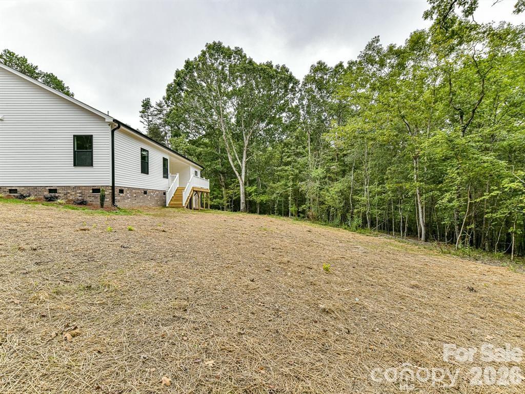 6720 Jesse Rushing Road Marshville, NC 28103 - Photo 25 of 28 a backyard of a house with large trees