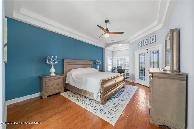 a bedroom with a large bed and a chandelier