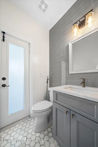 a bathroom with a sink a toilet and a mirror