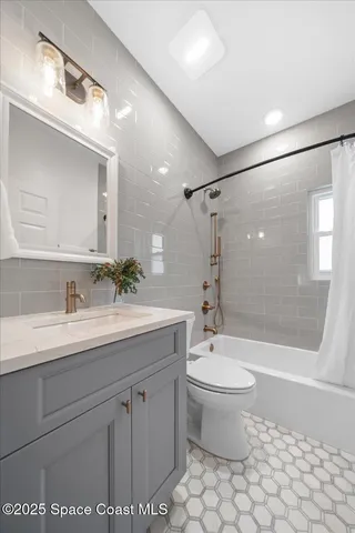 a bathroom with a granite countertop sink a toilet a mirror and shower