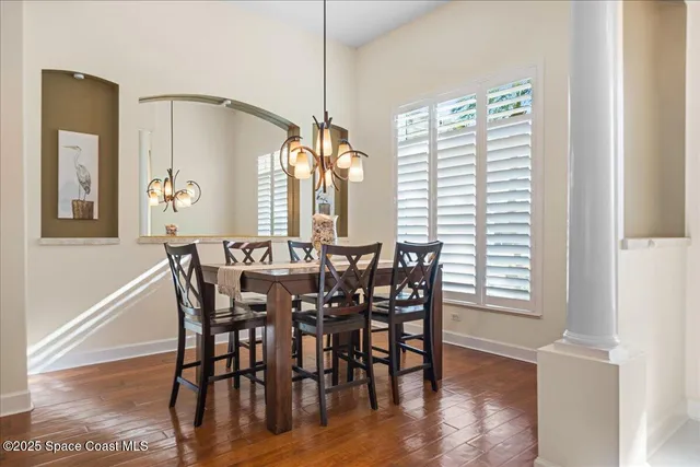 a view of a a dining room with furniture window and wooden floor