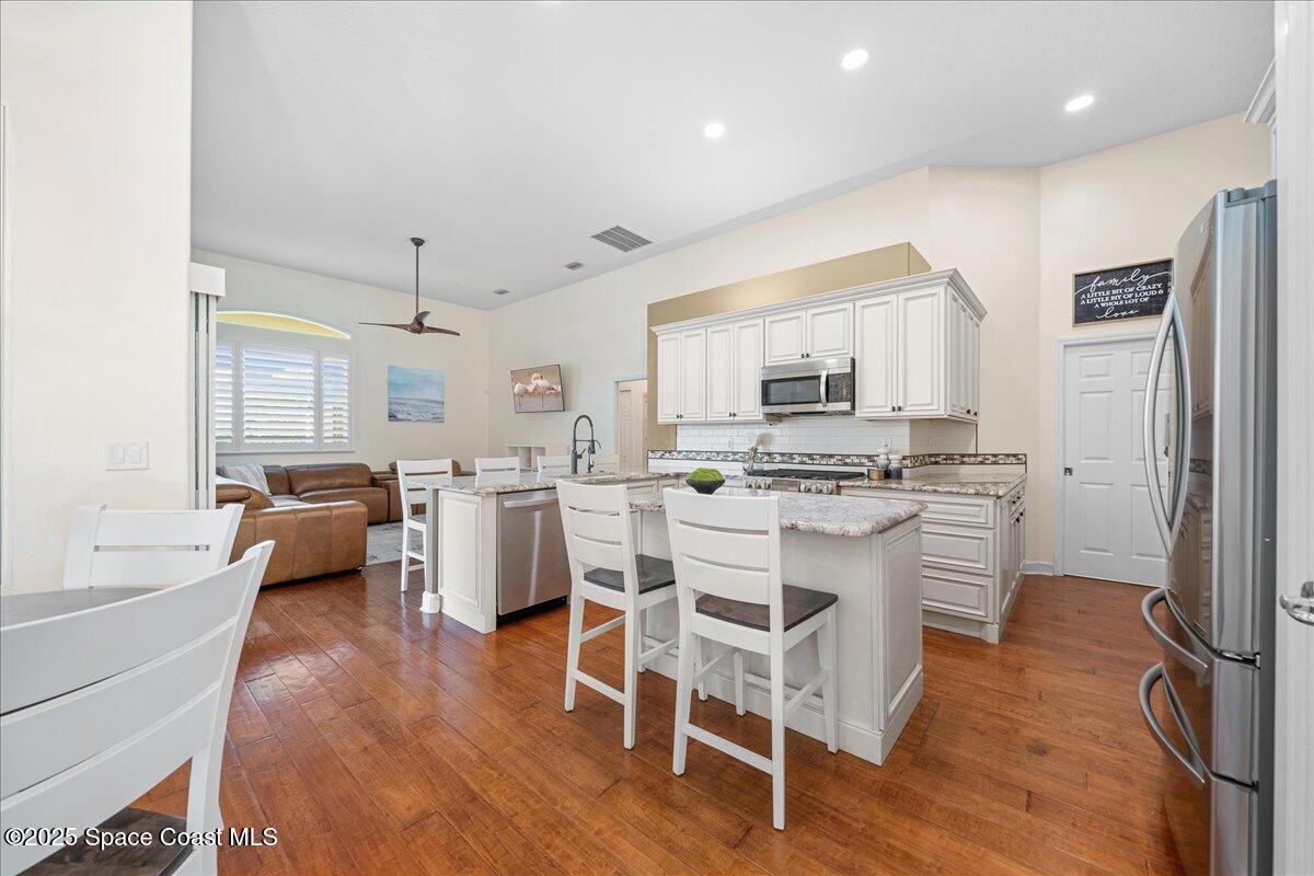 4329 Collingtree Drive Rockledge, FL 32955 - Photo 8 of 36 a kitchen with stainless steel appliances a stove a sink dishwasher a refrigerator with white cabinets and wooden floor