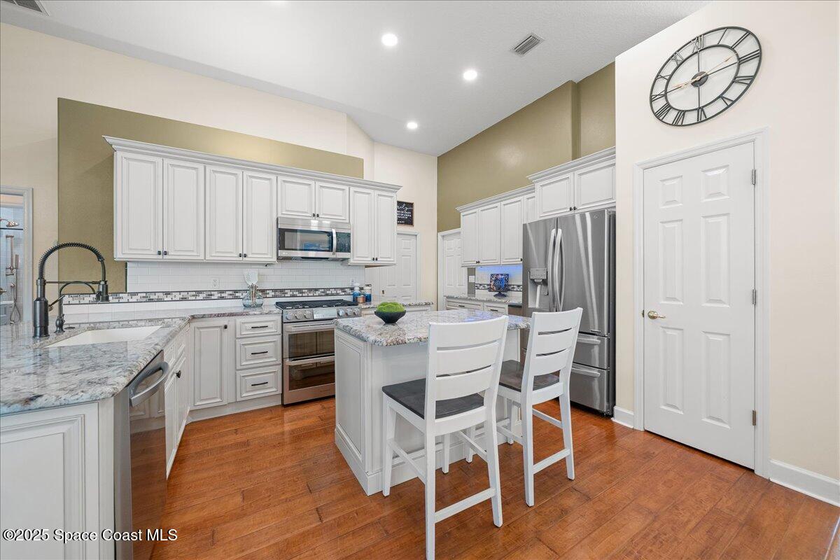 4329 Collingtree Drive Rockledge, FL 32955 - Photo 9 of 36 a kitchen with white cabinets and stainless steel appliances