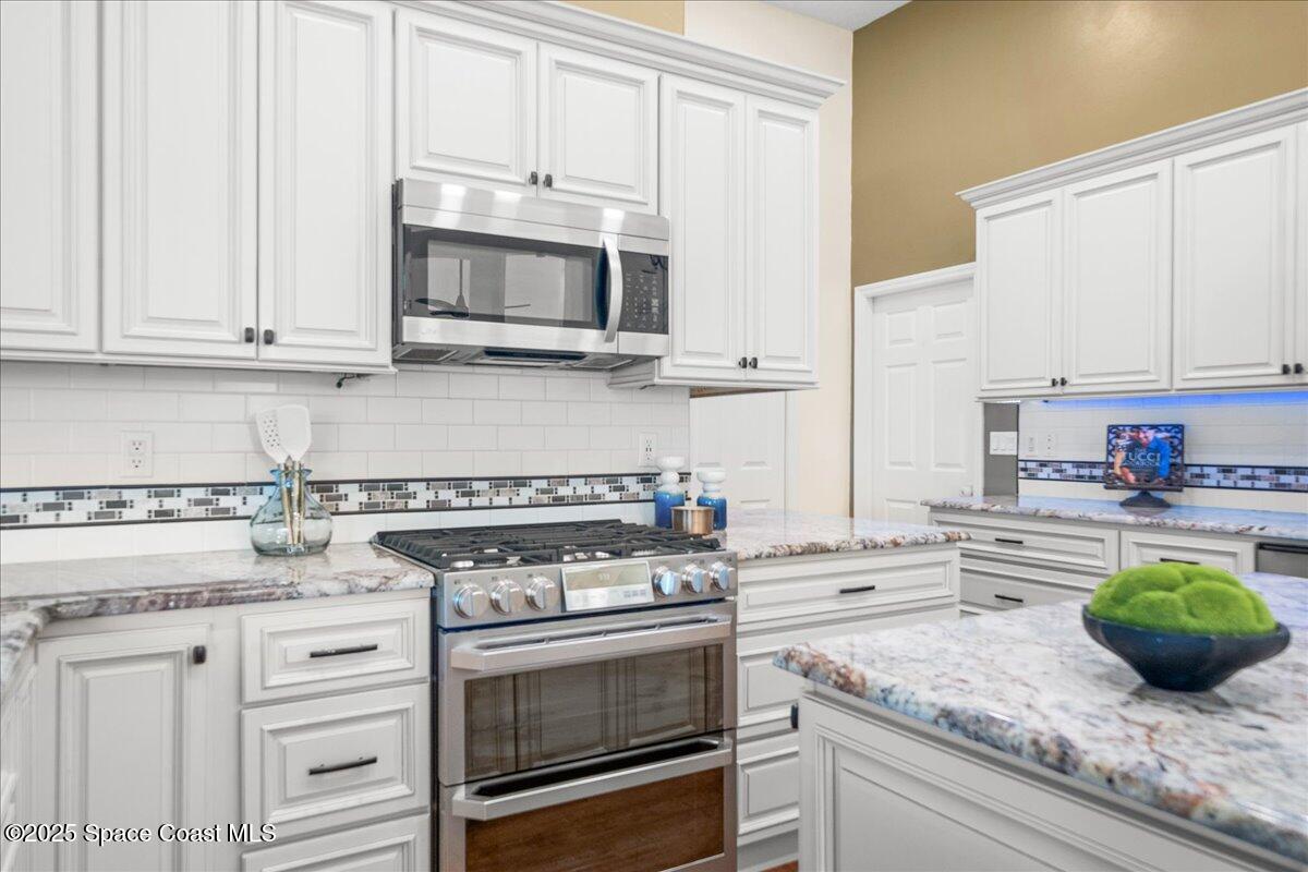4329 Collingtree Drive Rockledge, FL 32955 - Photo 10 of 36 a kitchen with granite countertop white cabinets and stainless steel appliances