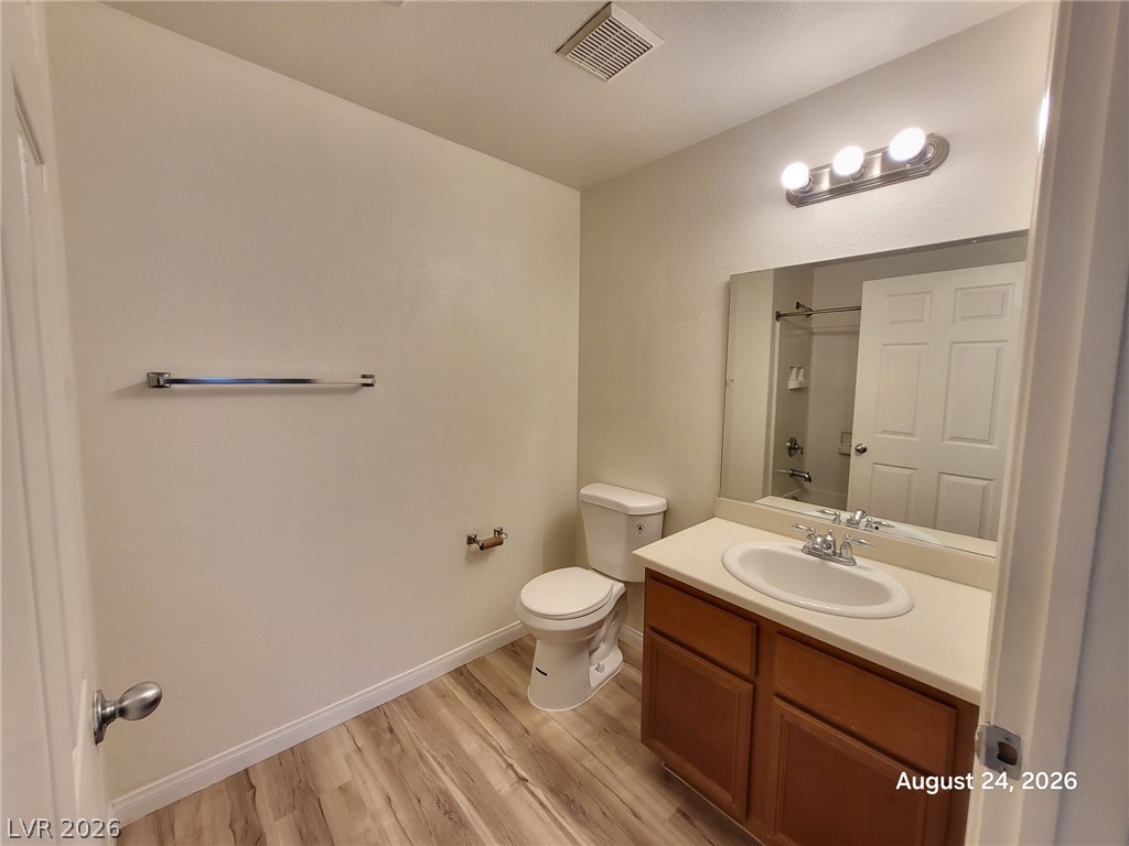 7701 West Robindale Road, Unit 125 Las Vegas, NV 89113 - Photo 9 of 16 Warm wood cabinetry and durable vinyl plank flooring define this functional secondary bathroom.