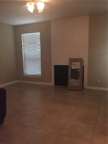 a view of a livingroom with an empty space and a window