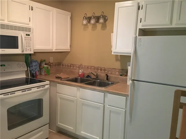 a kitchen with stainless steel appliances white cabinets and a sink