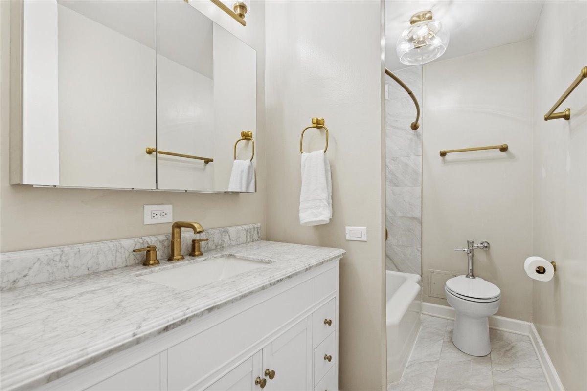 535 North Michigan Avenue, Unit 2204 Chicago, IL 60611 - Photo 12 of 26 a bathroom with a granite countertop sink a toilet and a shower