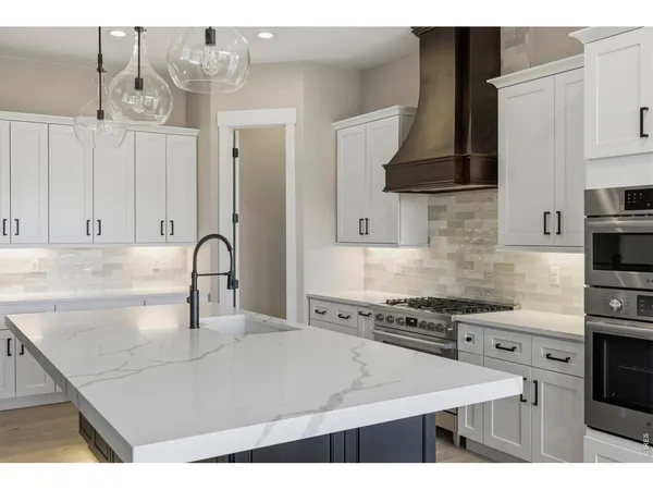 a kitchen with stainless steel appliances a sink a stove and cabinets