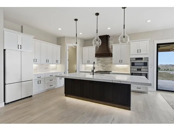 a large kitchen with cabinets and stainless steel appliances