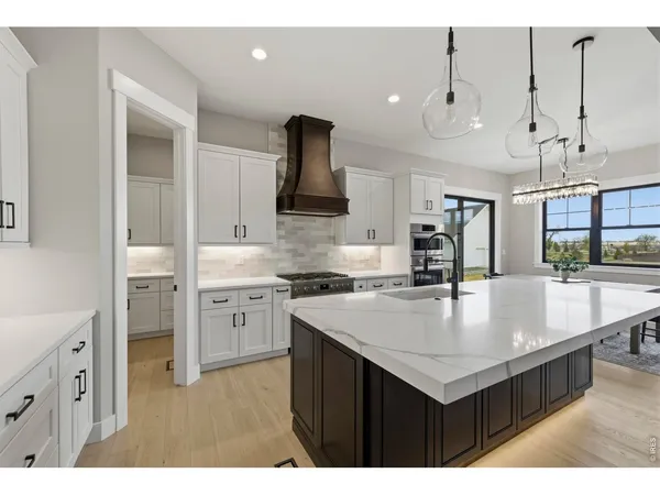 a kitchen with stainless steel appliances granite countertop a sink a stove and a refrigerator