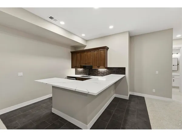 a kitchen with granite countertop a sink a stove and cabinets