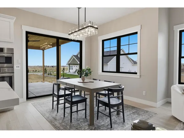 a view of a dining room with furniture large windows and wooden floor