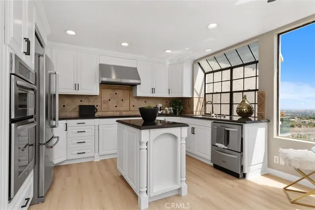 a kitchen with white cabinets and appliances
