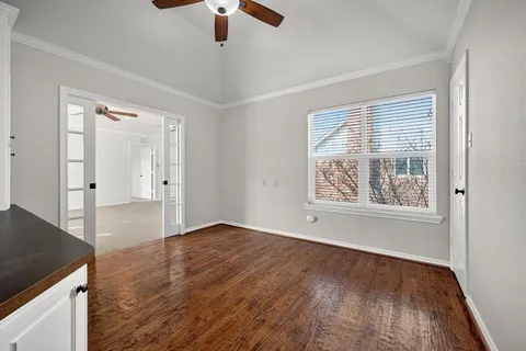 an empty room with a window and a fan
