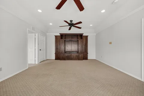 an empty room with windows and chandelier fan