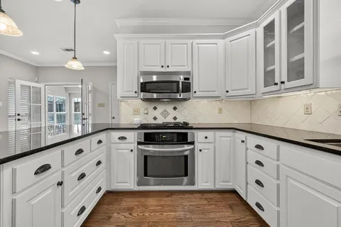 a kitchen with white cabinets and stainless steel appliances