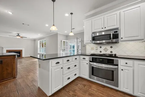 a kitchen with stainless steel appliances granite countertop a stove a sink and a microwave