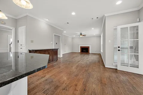a view of a big room with wooden floor and windows