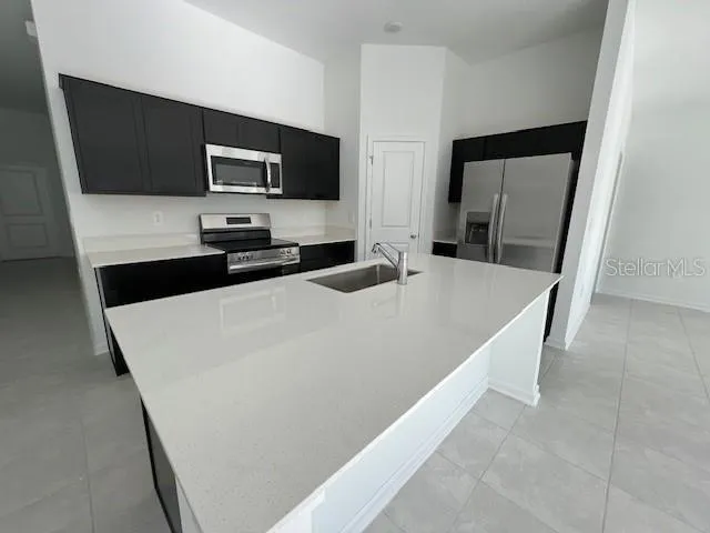 a kitchen with stainless steel appliances a refrigerator and a microwave