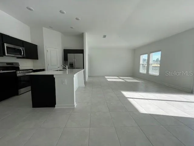 a kitchen with stainless steel appliances granite countertop a refrigerator and a stove top oven