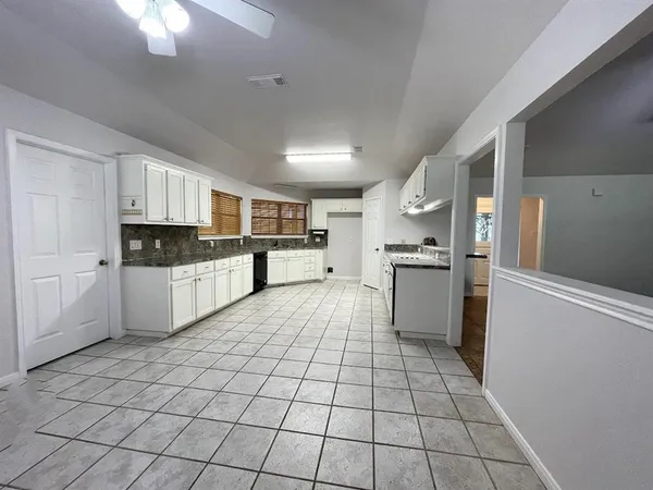 a large kitchen with a stove a sink dishwasher and a wooden cabinets