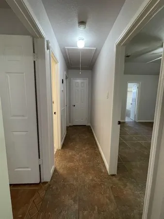 en empty room with windows and ceiling fan