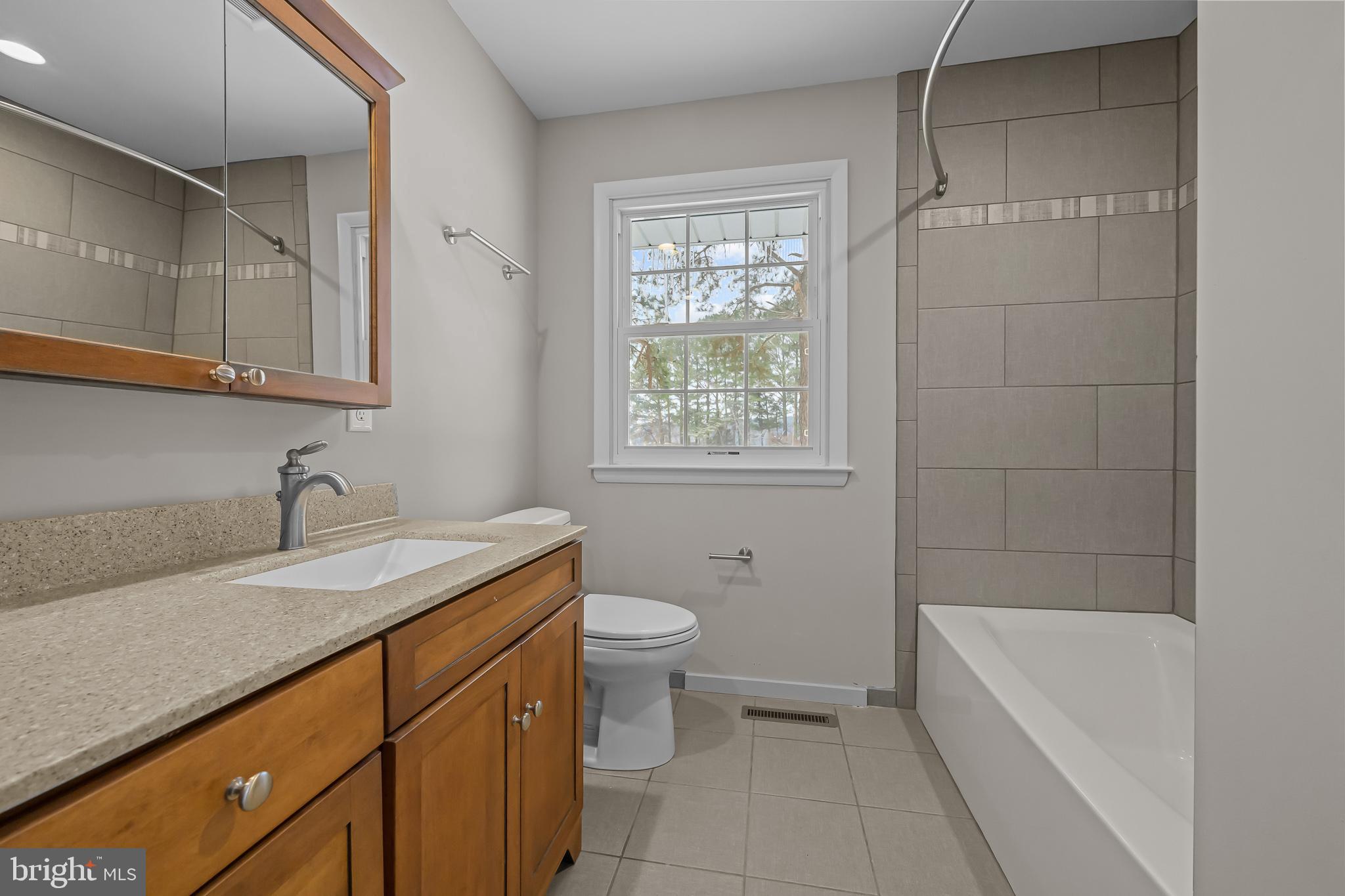 21830 Vaughn Road Georgetown, DE 19947 - Photo 18 of 39 a bathroom with a granite countertop sink a toilet and bathtub