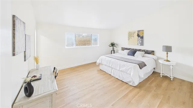 a bedroom with a bed and wooden floor