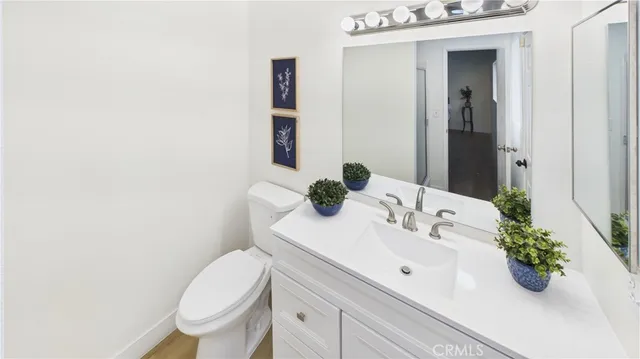 a bathroom with a sink vanity mirror and toilet