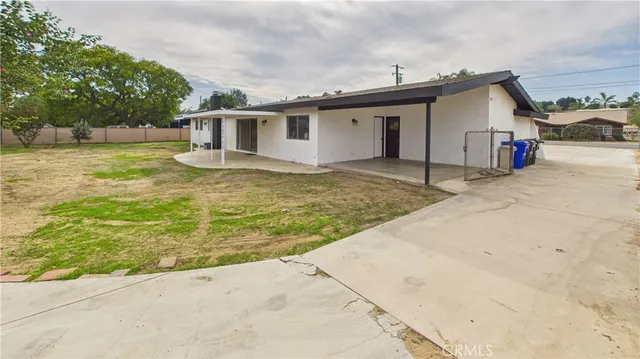 a view of a house with backyard and trees
