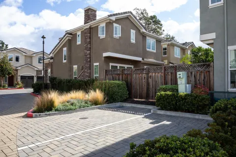 a front view of a house with a yard and potted plants