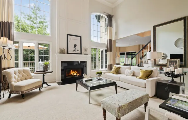 a living room with furniture a fireplace and a large window