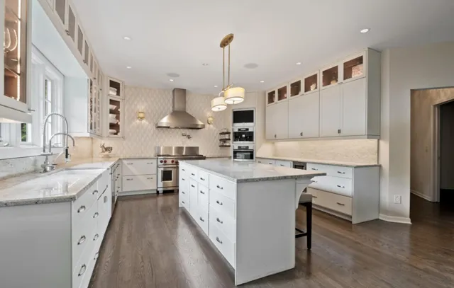a kitchen with white cabinets stove and refrigerator