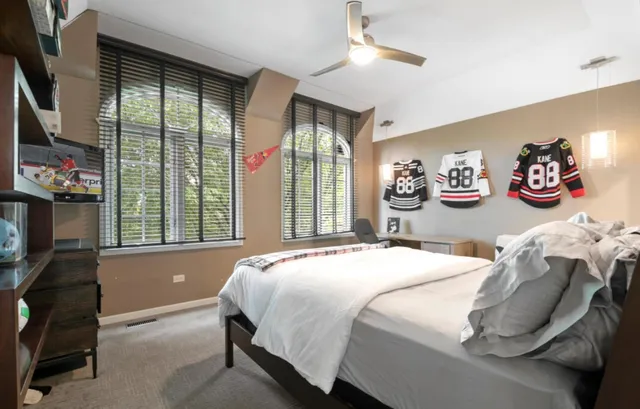 a bedroom with a bed and a dresser next to a window