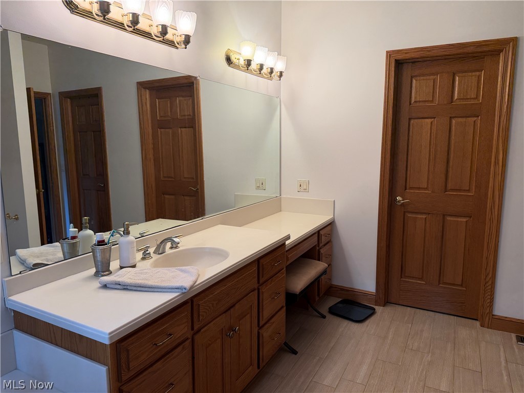 2363 Tabor Ridge Road Northeast New Philadelphia, OH 44663 - Photo 29 of 42 Double vanity featuring an integrated sink, expansive countertop, and wood-finish cabinetry
