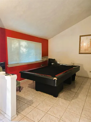 a room with furniture pool table and a flat screen tv