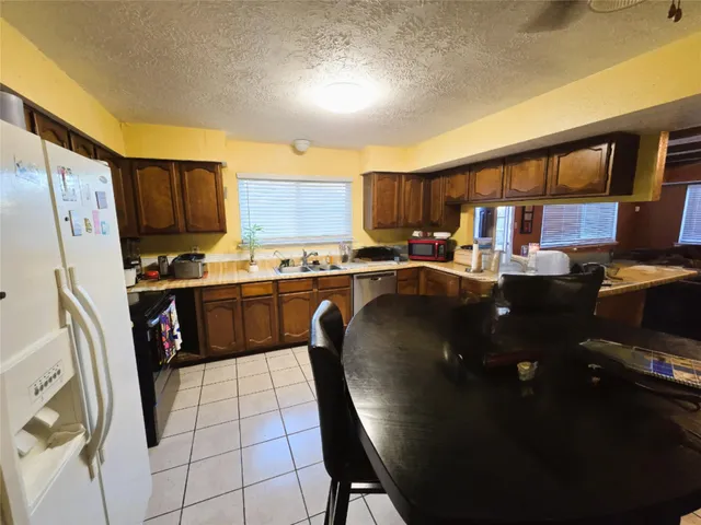 a kitchen with kitchen island granite countertop a sink stove and refrigerator