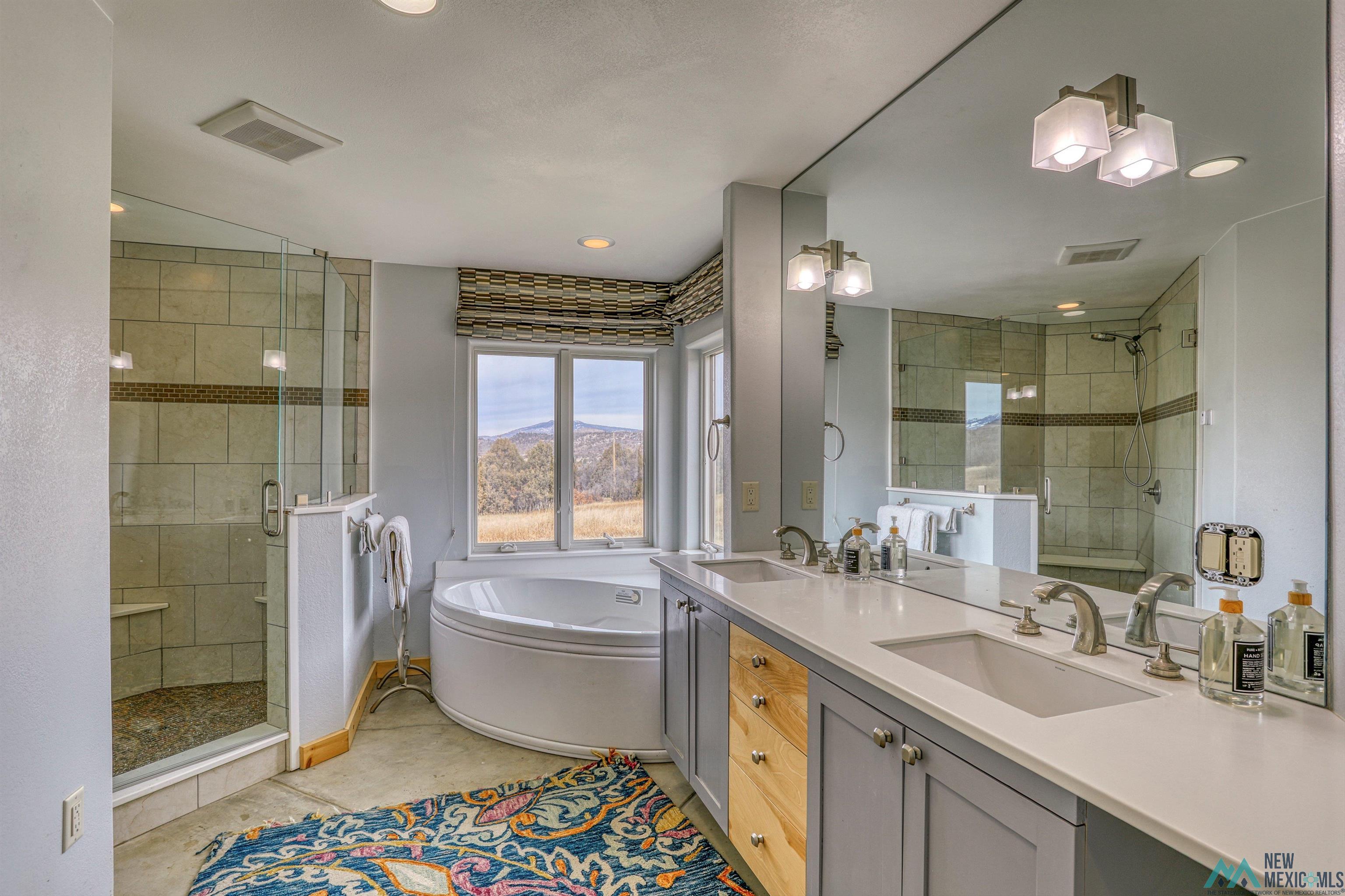 12 Horn Toad Road Chama, NM 87520 - Photo 30 of 52 Full bathroom with double vanity, a stall shower, a garden tub, and light tile patterned floors