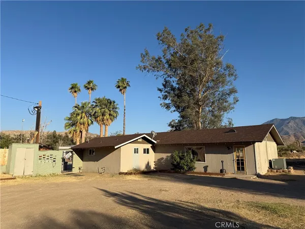 a front view of a house with a tree