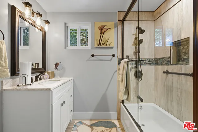 a bathroom with a tub sink a mirror and a shower