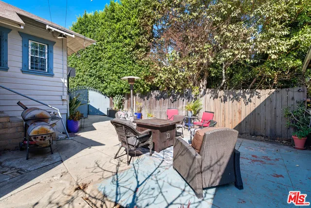 a backyard of a house with barbeque oven table and chairs