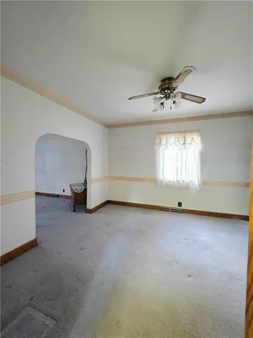 an empty room with a window and a ceiling fan