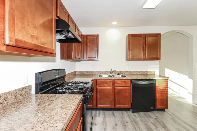 a kitchen with stainless steel appliances granite countertop a stove a sink and a microwave