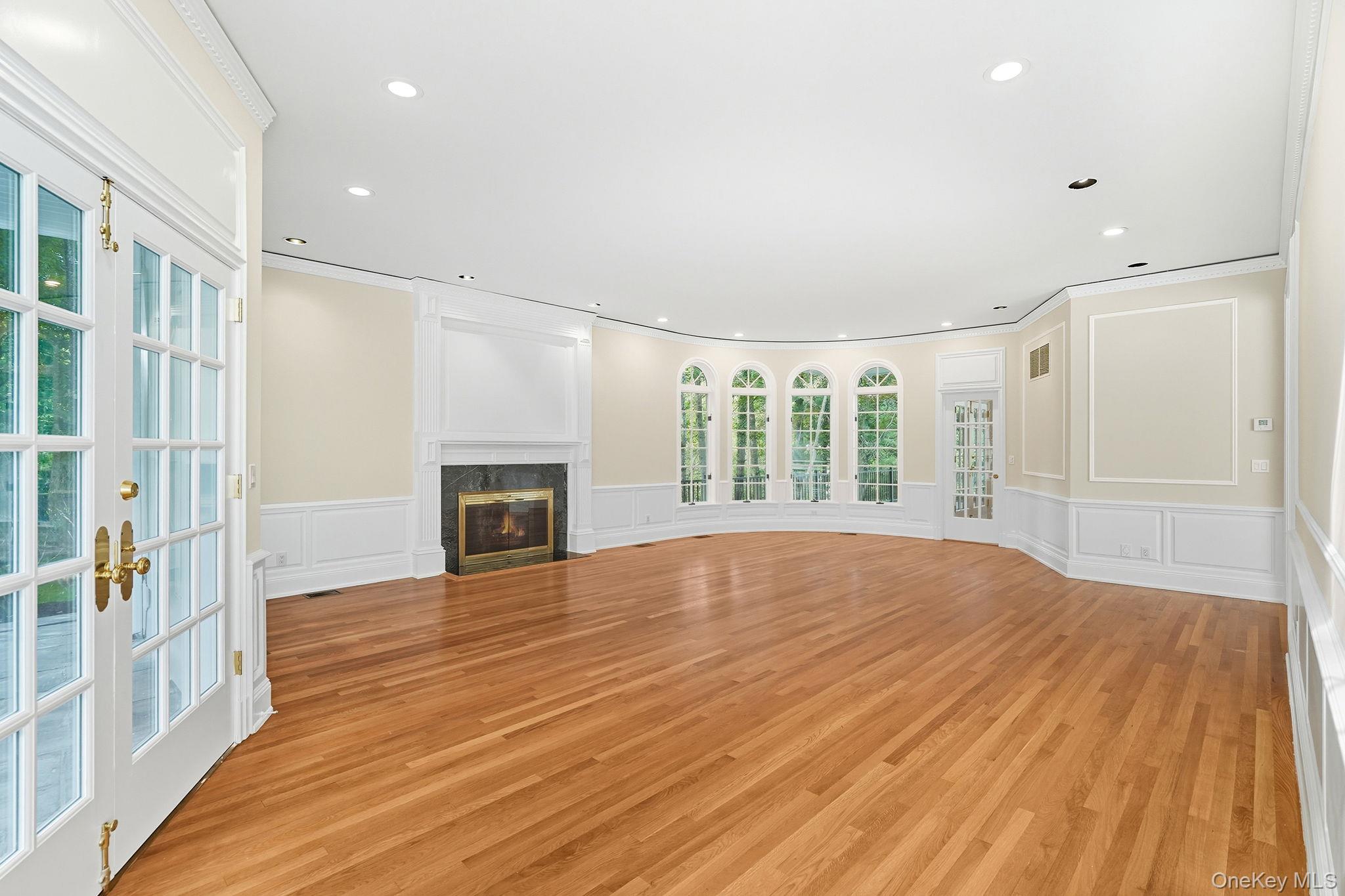 10 Cooper Road Scarsdale, NY 10583 - Photo 9 of 47 a view of empty room with wooden floor and fireplace